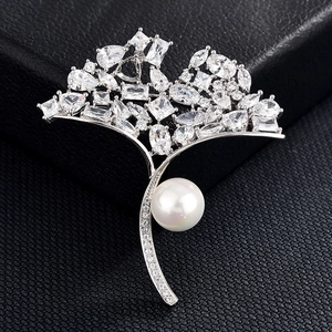 Vue détaillée d'une broche feuille de ginkgo argentée avec zircons et une perle blanche