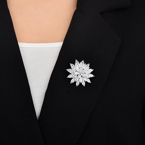 Macro view of snowflake zircon brooch pinned on a black suit lapel with silver finish