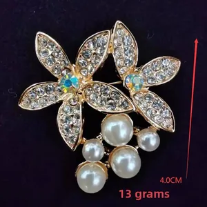 Detail of floral brooch with white rhinestones and pearls measuring 4.0cm height