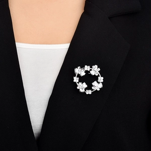 Detailed close-up of a sparkling zircon butterfly wreath brooch on a black blazer lapel
