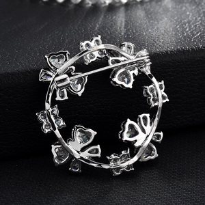 Elegant silver zircon butterfly wreath brooch with a secure pin back on black leather