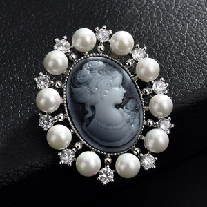Détail macro d'une broche camée vintage avec perles et cristaux sur cuir noir