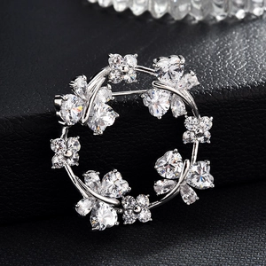 Sparkling zircon butterfly wreath brooch with silver finish on dark leather background