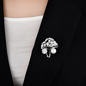 Détail de la broche champignon argentée avec perles et zircone sur un blazer noir