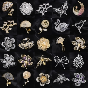 Grille de 25 modèles de broches élégantes en zircone sur un tissu de satin noir luxueux