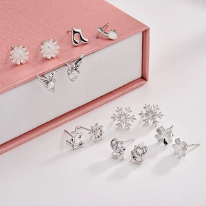 Detailed close-up of 7-pair sterling silver earring set with crystals in a pink gift box