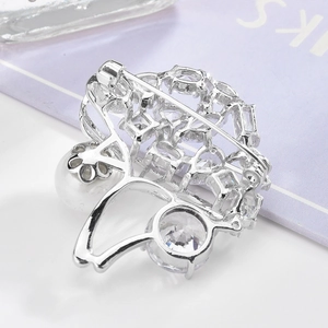 Élégante broche champignon en argent avec perles et zircone sur un livre violet