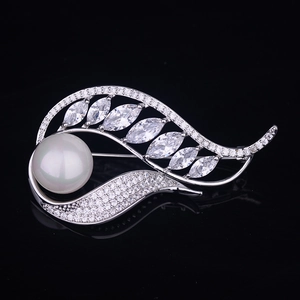 Élégante broche plume argentée avec une grande perle blanche et des zircons sur fond noir