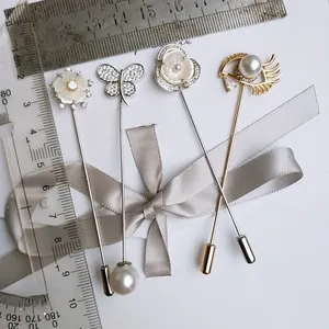 Detailansicht von vier Zirkon-Broschen mit Blumen-, Schmetterlings- und Augenmotiven