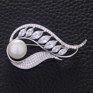 Élégante broche en forme de feuille avec perle blanche et zircons sur monture argentée