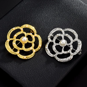 Détails des broches camélia évidées avec perles élégantes sur cuir noir texturé