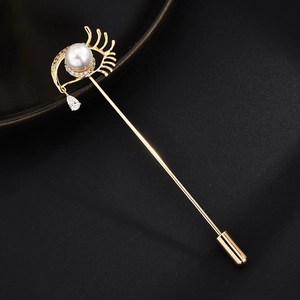 Detail der augenförmigen Anstecknadel mit weißer Perle und tropfenförmigem Zirkonia
