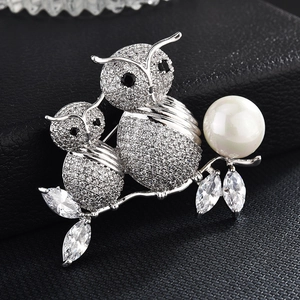 Spilla a forma di gufo in argento con zirconi e perla bianca su sfondo in pelle nera