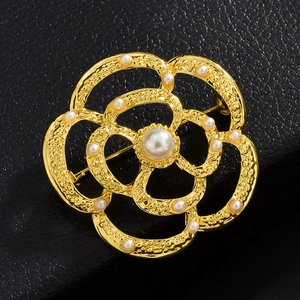 Vue détaillée de la broche camélia en or avec perle centrale et texture martelée élégante