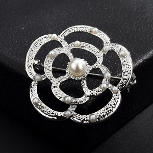 Vue détaillée de la broche fleur de camélia avec pétales argentés texturés et perles