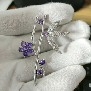 Detailed view of bamboo joint brooch with purple gemstones and white micro-zirconia inlays