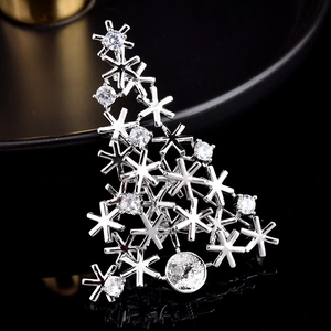Macro detail of silver snowflake Christmas tree brooch with sparkling zircons
