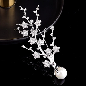 Détail de la broche branche argentée ornée de zircons brillants et d'une perle blanche