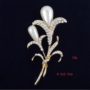 Détail de la broche fleur avec perles en forme de goutte et strass blancs 6.5x3.5cm