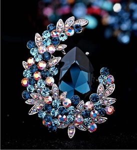Elegant silver brooch featuring deep blue pear-shaped crystal and colorful rhinestones