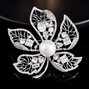 Detailed macro view of floral brooch with white pearl and sparkling crystals