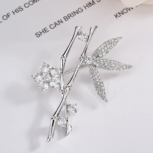 Elegant bamboo leaf and flower brooch in silver-tone metal with pavé-set cubic zirconia