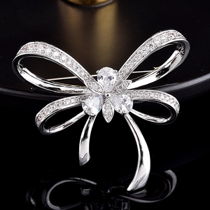 Élégante broche nœud argentée avec zircons micro-sertis et cristaux en goutte