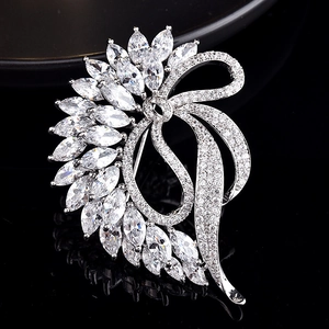 Elegant silver-toned flower brooch featuring marquise-cut zircons and ribbon bow design