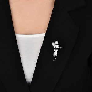 Detail of silver mouse brooch with white zircon stones on a black suit jacket lapel