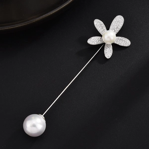 Detailansicht einer langen silbernen Brosche mit Kristallblume und doppelten Perlenakzenten