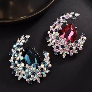 Austrian crystal crescent brooches in deep blue and rose red tones on black textured background