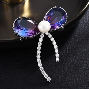 Vue macro de la broche papillon avec cristaux violets, perle et franges de zircon