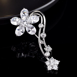 Macro detail of silver flower brooch featuring elegant zircon petals and tassel pendants
