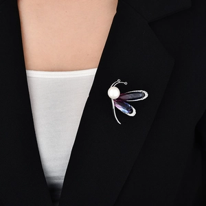Détail de broche papillon avec ailes en cristal violet dégradé et perle blanche