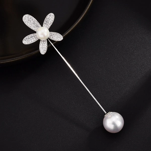 Detail-Makroaufnahme einer silbernen Blumenbrosche mit Zirkonia und weißen Perlen
