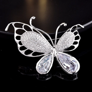 Macro shot of silver butterfly brooch with pear-cut crystals and zircon inlay details