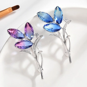 Detailed macro view of crystal flower brooches with purple and blue zircon accents