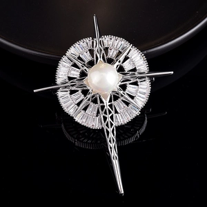 Vue macro d'une broche en argent avec étoile boussole, perle centrale et zircons baguettes