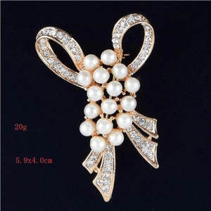 Détail de la broche fleur en perles avec nœud élégant, dimensions 5.9x4.0cm et poids 20g