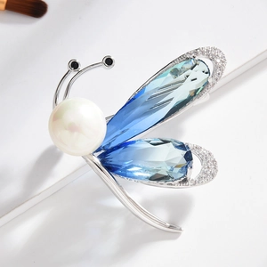 Élégante broche insecte avec cristaux bleus, perles blanches et zircons sur blanc