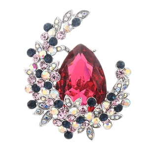 Detail of vintage silver brooch with large red pear crystal and multicolor stones