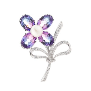 Detail of flower brooch with purple gradient gems, white pearl, and silver ribbon design