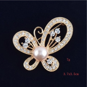 Détail de la broche papillon 3,7x3,5cm sertie de strass et d'une perle centrale chic