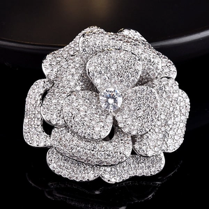 Gros plan d'une broche camélia en zircons sertis avec couches de pétales argentés
