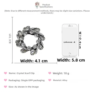 Détails de la broche en cristal mesurant 4,1cm x 4,1cm à côté d'un smartphone