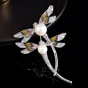 Détails de la broche libellule argentée avec perles et ailes en émail coloré