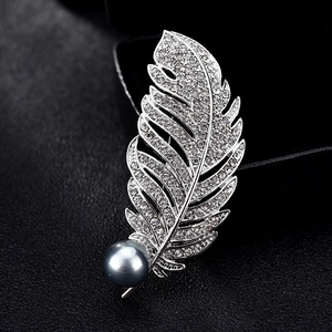 Broche plume argentée élégante avec des strass brillants et une perle bleu grisâtre