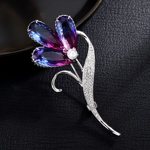 Detailaufnahme einer Zirkon-Blumenbrosche mit violetten Kristallblättern auf Leder