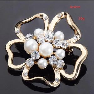 Vue détaillée de la broche fleur avec perles et strass sur un miroir noir poli