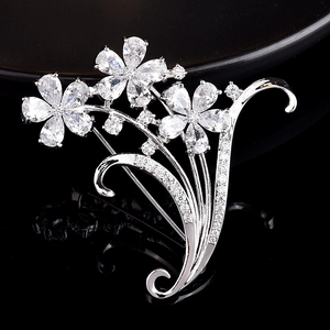 Vue détaillée de la broche fleur argentée avec zircons cubiques sur fond miroir noir chic